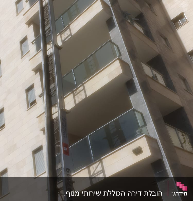 מנוף הובלה ליד בניין גבוה עם מרפסות